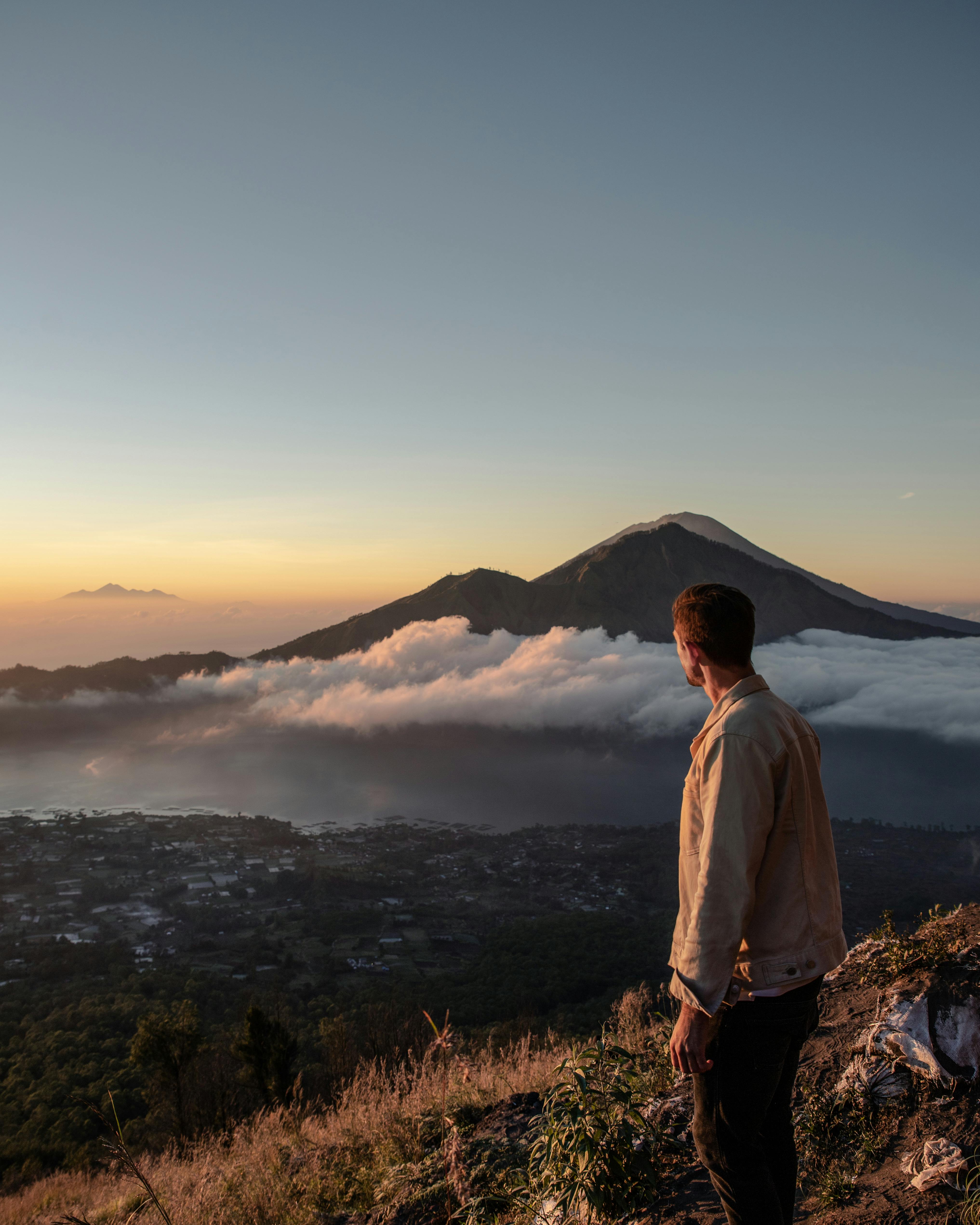 Majestic sunrise over Mount Batur volcano with misty clouds and serene lake waters