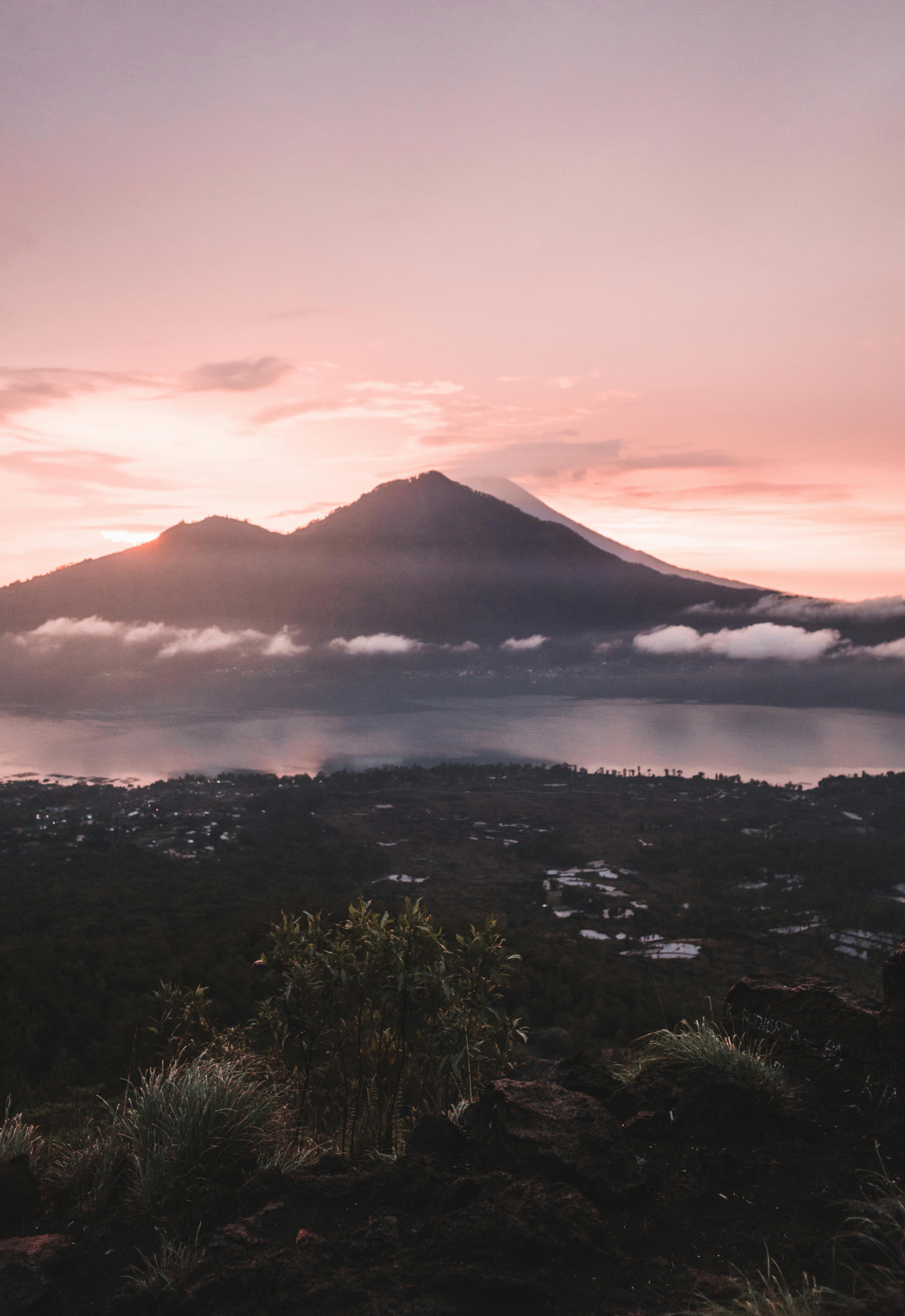 Dramatic volcanic crater and caldera of Mount Batur at sunrise with misty lake